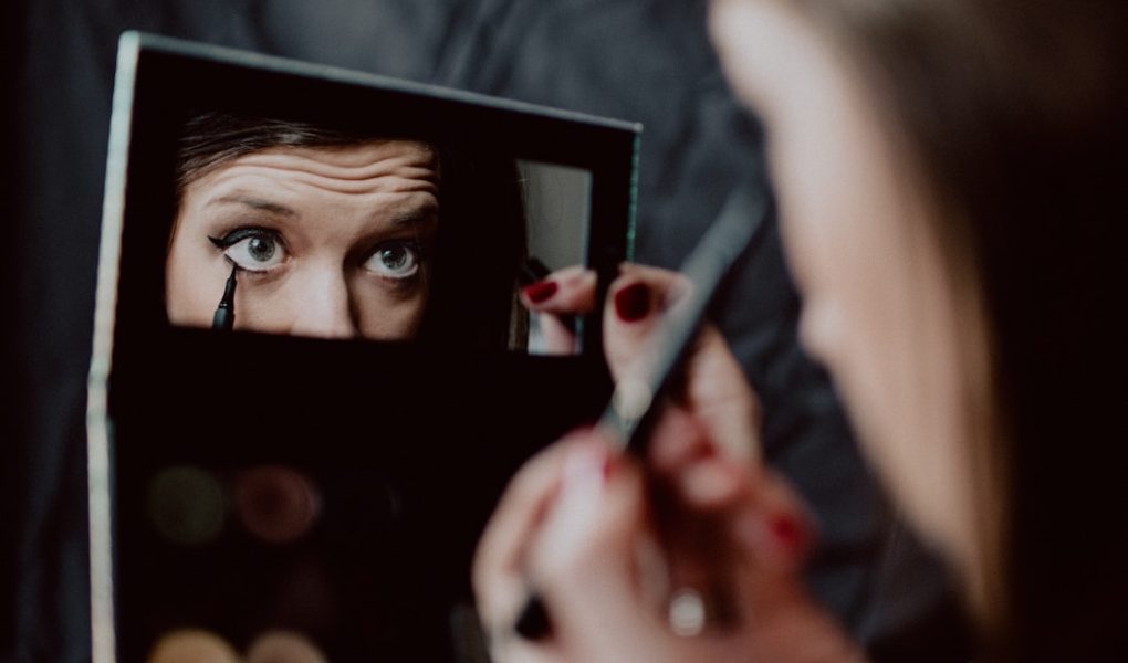 woman holding black framed mirror