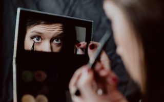 woman holding black framed mirror