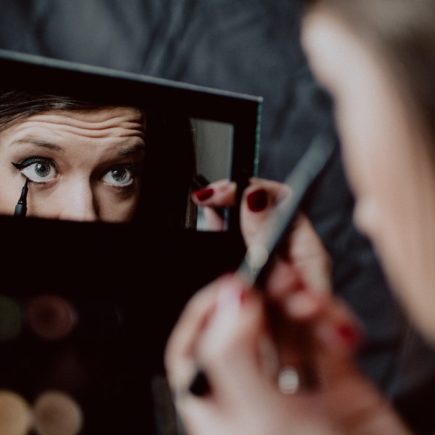 woman holding black framed mirror